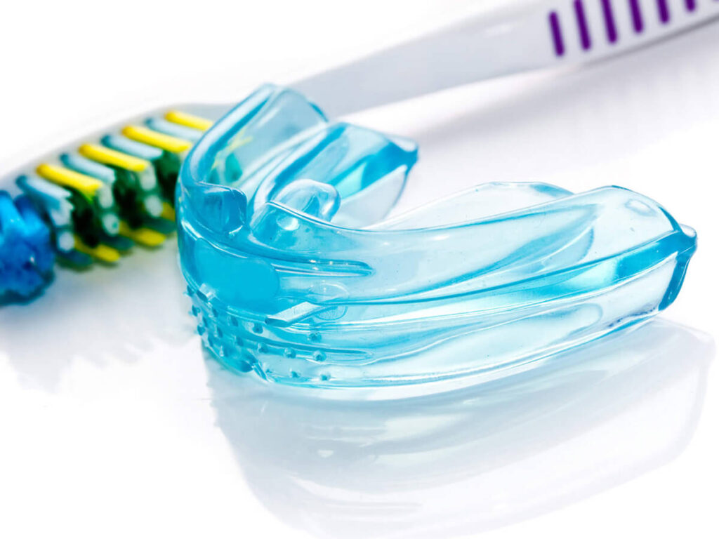blue dental mouthguard and a toothbrush