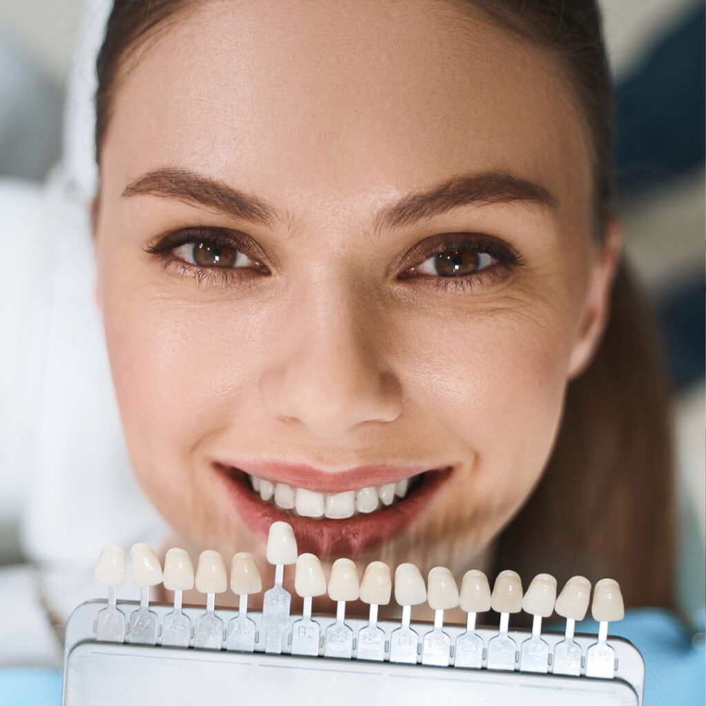 smiling woman checking her tooth shade